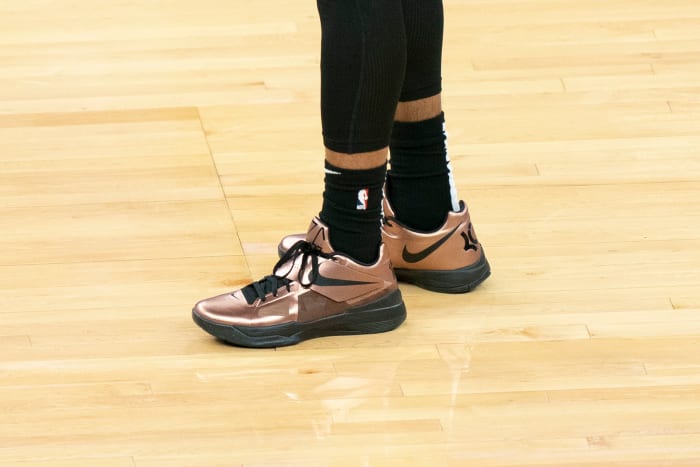 View of copper and black Nike KD shoes.